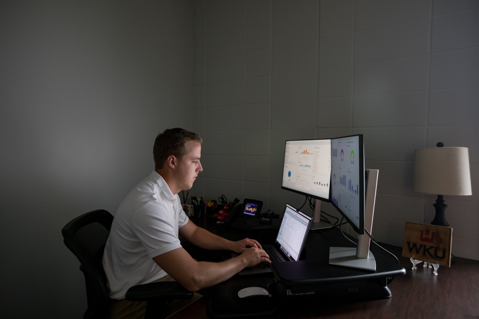 A cybersecurity student works on a laptop.