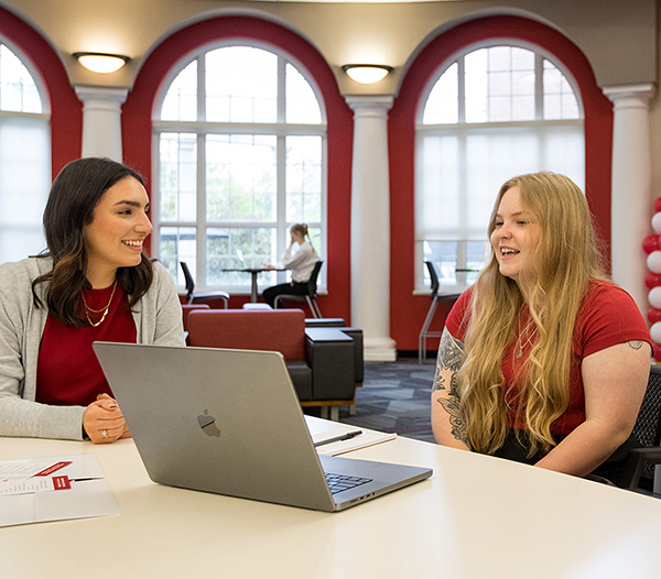 Digital Clinical Mental Health Counseling students sitting around a laptop