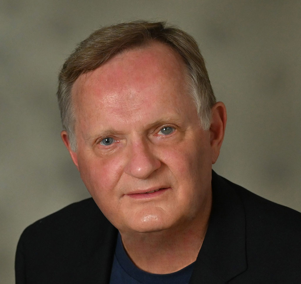 headshot of middle-age white man wearing a dark shirt