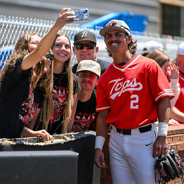 WKU Baseball player meets with fans for a photo.