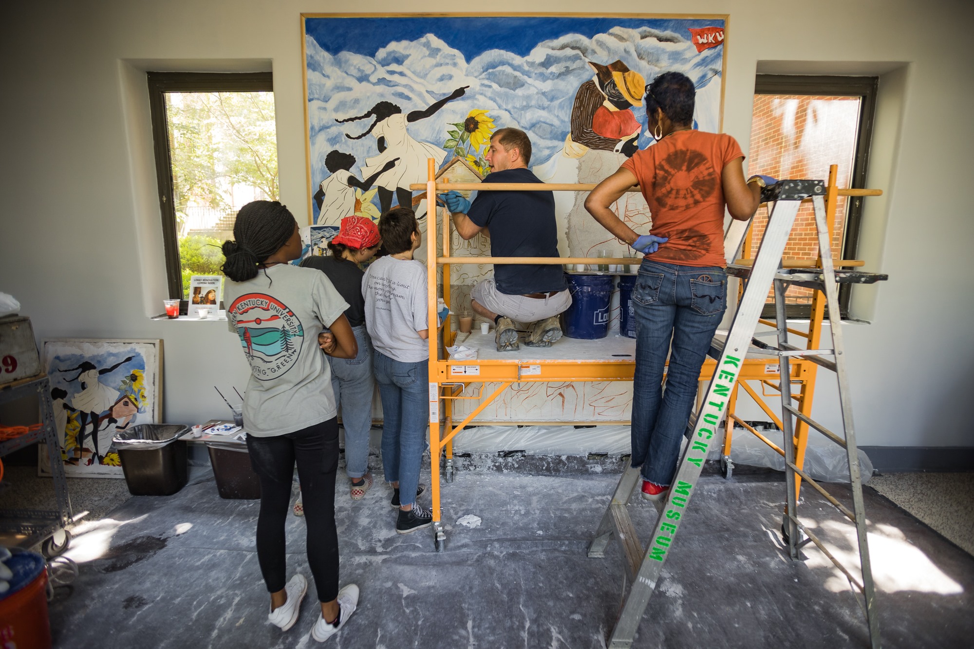 Five people stand in front of the Jonesville fresco mural at the Kentucky Museum