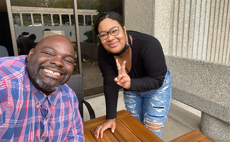 student hanging out with dean on patio